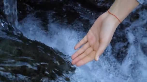 Vrouw legt haar hand onder water — Stockvideo