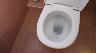 Su beyaz tuvaleti sifonu çeker.