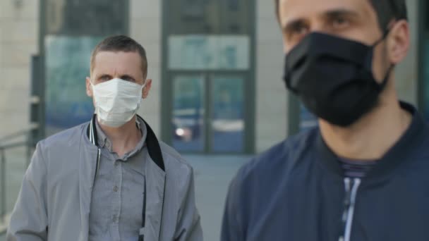 Twee mannen in het gezicht maskers op straat — Stockvideo