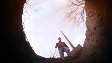 Bir adam mezar kazar.