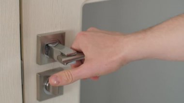 Kapı kolu elini tutar.