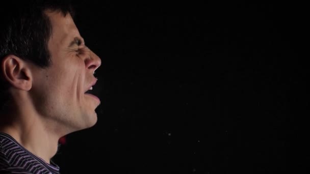 El hombre estornuda y esparce partículas de saliva por el aire — Vídeos de Stock