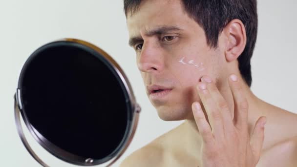 Чоловік наносить крем на обличчя — стокове відео