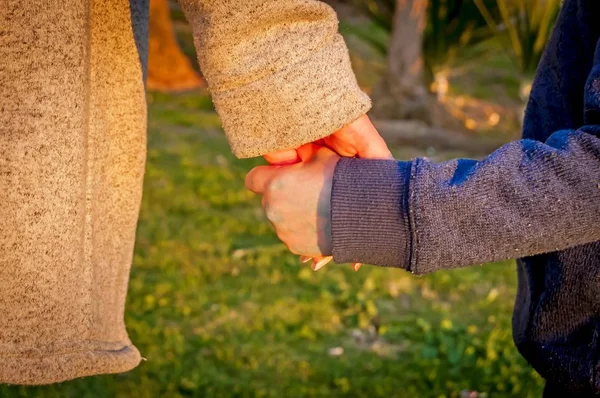 Young Caucasian mother holding hand of her baby son. — Stock Photo, Image