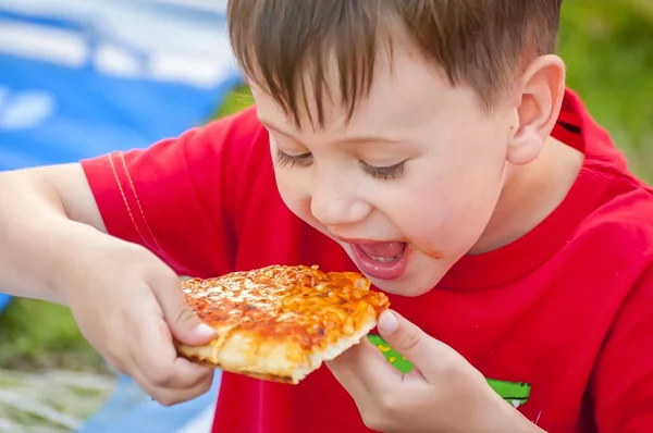 Cute little Caucasian kid eating pizza. — Stock Photo, Image