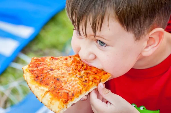 Kaukasiska barn äter pizza — Stockfoto