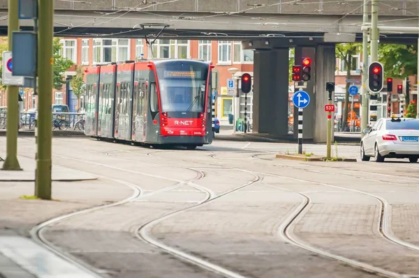 THE HAGUE (DEN HAAG), НИДЕРЛАНДЫ. 19 июля 2017 года. Современный красный трамвай перед центральным вокзалом Гааги (Den Haag Centraal ). — стоковое фото