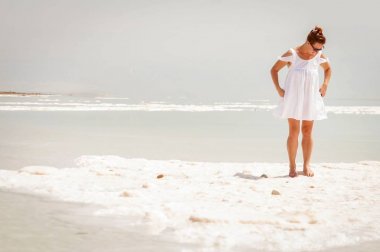 Dead Sea vahşi doğa yerinde beyaz elbiseli güzel kız.