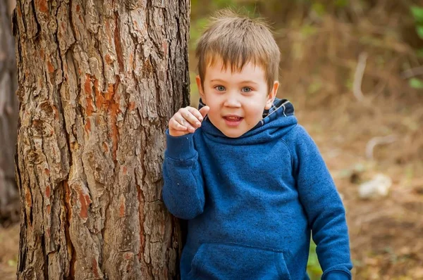 Schattige ondeugende jongen in het bos. — Stockfoto