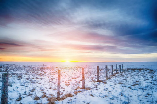 Winter sunset on the lake with fence posts — Stock Photo, Image