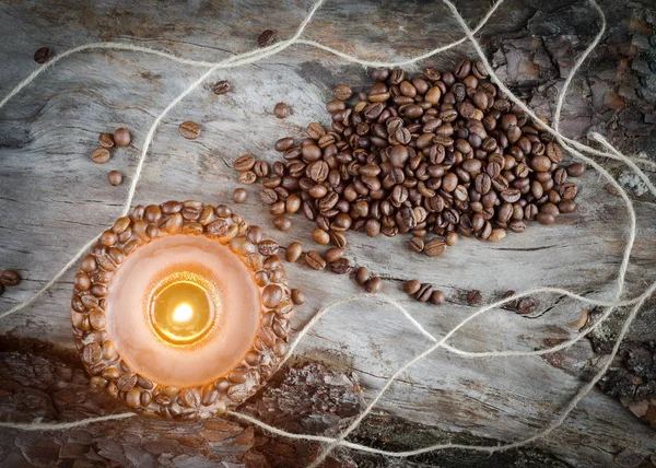 Burning aromatic coffee candle and coffee beans on aged wood — Stock Photo, Image