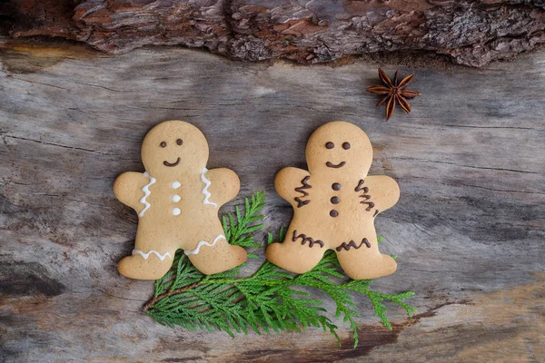 Happy gingerbread people on aged wood — Stock Photo, Image