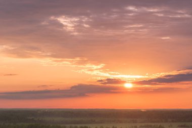 Gün batımında renkli gökyüzü ve orman siluet.