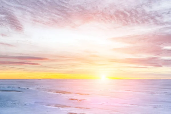 Brzdění ledu na zamrzlém jezeře, západ slunce v zimě. — Stock fotografie