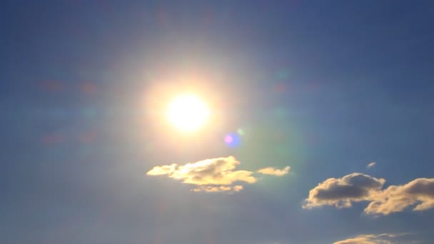 Glödande solen med moln på en blå bakgrund. Tidsfördröjning — Stockvideo