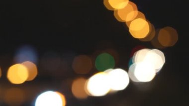 Bulanık turuncu, sarı, kırmızı, mavi, yeşil, beyaz ışıklar siyah kasaba sokaklarında araçların. Odak arka plan dışında