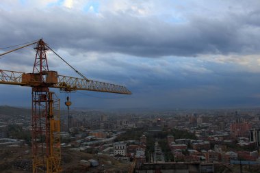 Turuncu yüksek inşaat vinç arka plan cityscape, mavi gökyüzü ve bulutlar karşı
