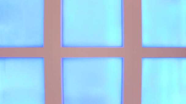 Ondas móveis de cores diferentes, em uma parede quadrada envidraçada. Na focagem — Vídeo de Stock