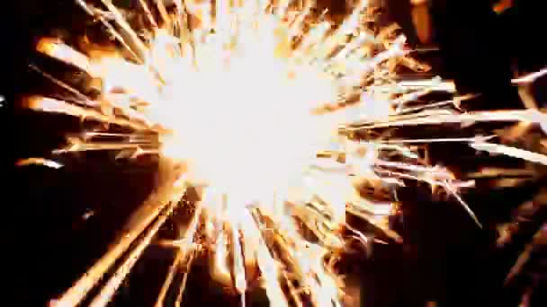 Lumière du Bengale brûlant avec des étincelles brillantes sur fond noir. Gros plan vidéo .