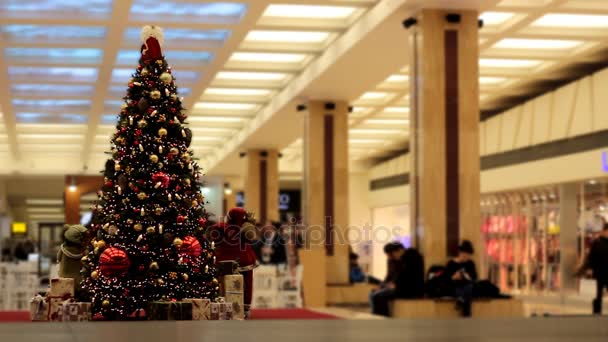 Defocused 걷는 사람들과 쇼핑 센터에서 크리스마스 트리 — 비디오