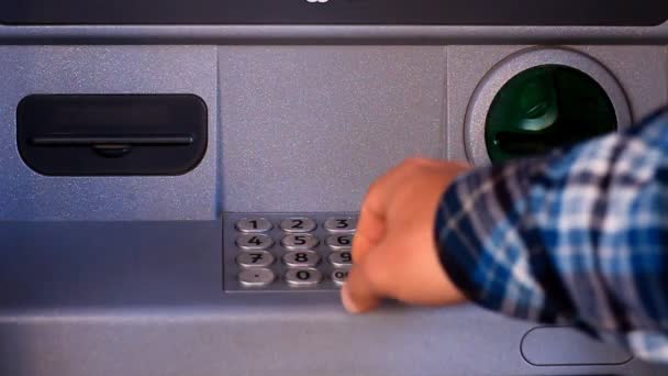 A persons hand inserting a credit card into an ATM, dialing password, and taking out a credit card from the ATM — Stock Video