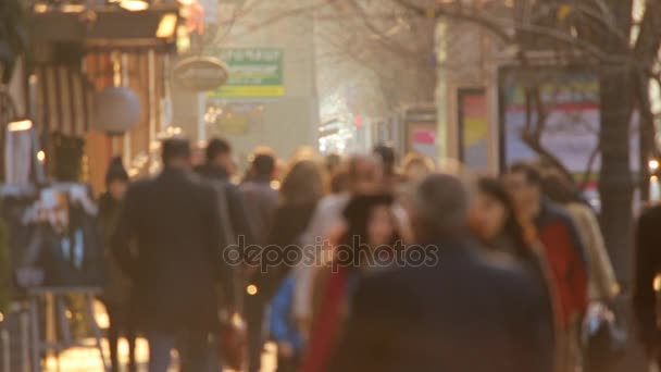 Pessoas caminhando no fundo por do sol dourado na cidade. Vídeo desfocado — Vídeo de Stock