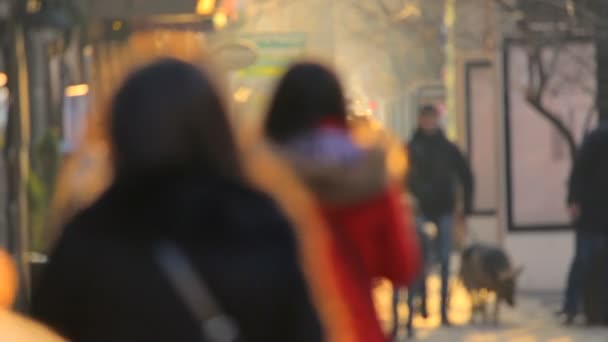 Gente caminando sobre el fondo del atardecer dorado en la ciudad. Vídeo desenfocado — Vídeo de stock