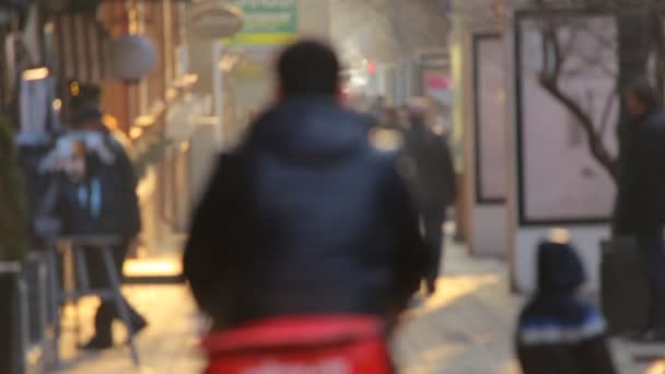 Анонимные люди, идущие на фоне золотого заката в городе. Разряженное видео . — стоковое видео