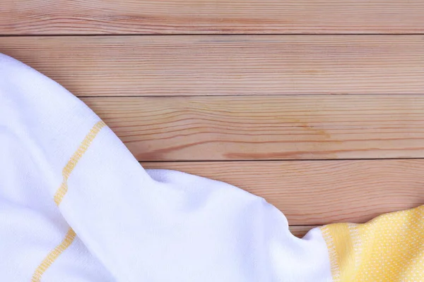 stock image White, yellow towel on wooden kitchen table. View from above with copy space for text.