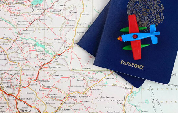 Travel concept. Pieces of two blue passports and toy airplane on a map. View from above.