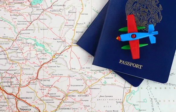 Concept de voyage. Des morceaux de deux passeports bleus et d'un avion jouet sur une carte. Vue d'en haut . Images De Stock Libres De Droits