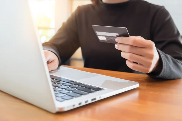 Online betaling "Woman's handen houden van een credit card en het gebruik van la — Stockfoto