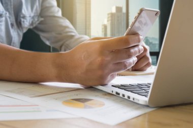 Akıllı telefon kullanma ve defter üzerinde bazı veri yazma iş adamı