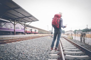 Sırt çantası ve harita üzerinde ile tren istasyonunda tren ile seyahat 
