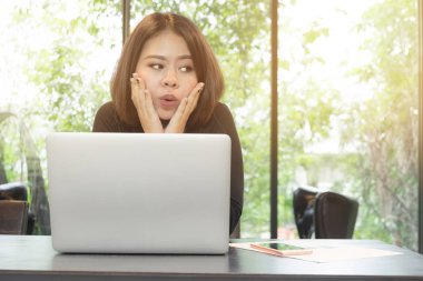 Mutlu genç güzel kadın Laptop istimal onun ofisinde