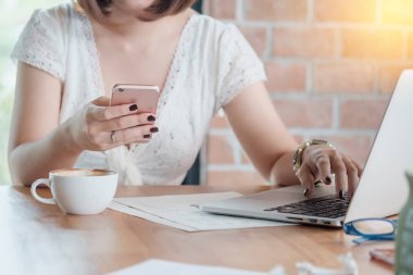 Bir kafede bir akıllı telefon kullanan yakışıklı kadın kapatmak