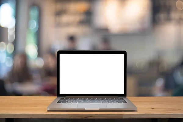 Laptop with blank screen on table. coffee shop blurred backgroun