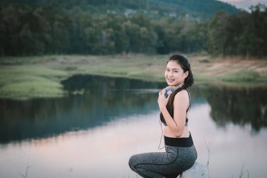 Genç Asyalı kız runner molası verdikten ve müzik