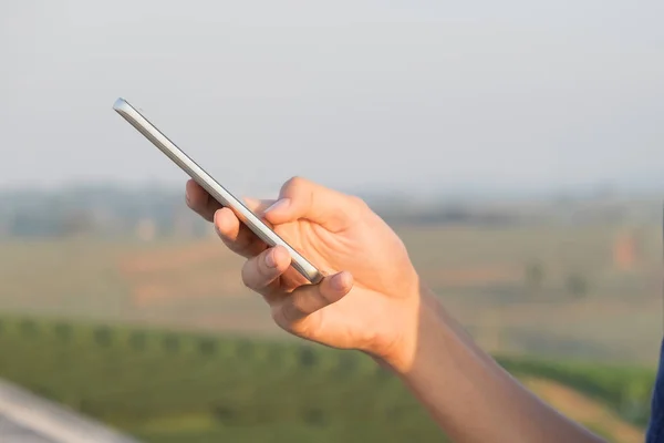 Primer plano de las manos del hombre usando el teléfono inteligente . — Foto de Stock