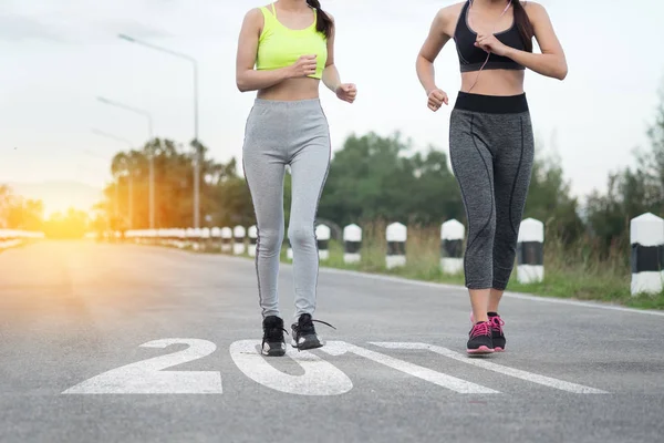 Dos mujeres jóvenes corriendo en línea de carretera con texto 2017 año, Inicio — Foto de Stock