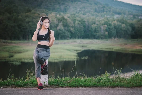 Música y fitness. Mujer joven en ropa deportiva con auriculares ex — Foto de Stock