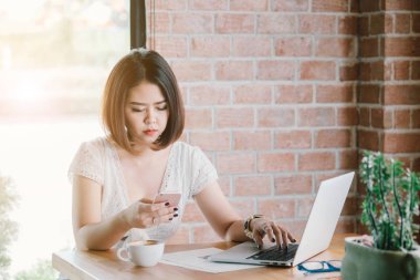 Güzel Asyalı kadın gülümsüyor bir akıllı telefon istimal süre 
