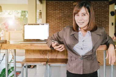 Güzel Asyalı kadın gülümsüyor bir akıllı telefon istimal süre 