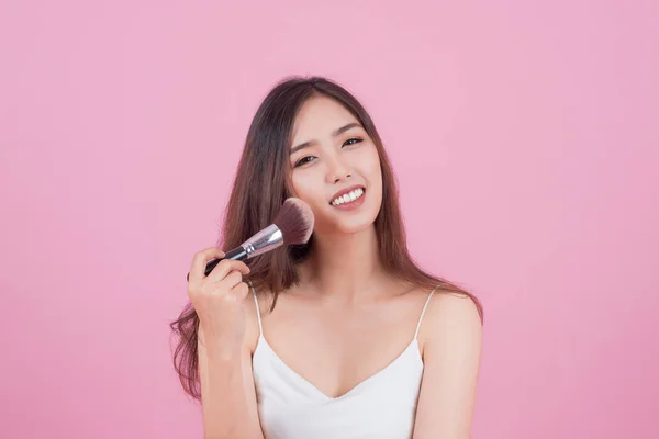 Beauty Asian Girl tan skin  with Makeup Brushes. She smiling and