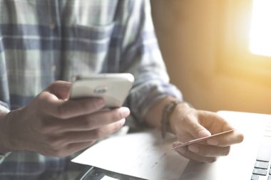 Bir kredi kartı tutan ve lapto kullanarak online ödeme, adam'ın eller