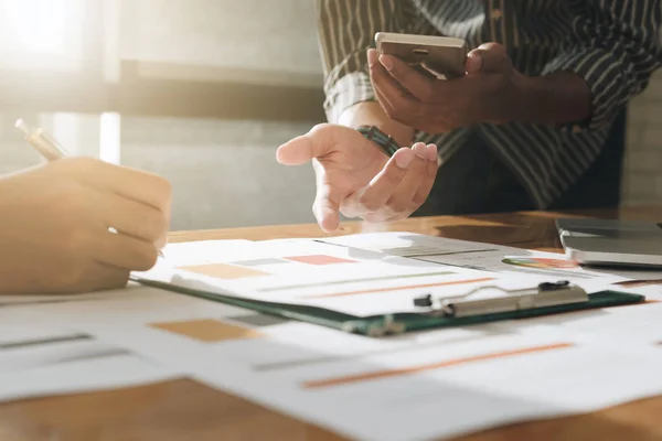 Businessman and partner discussing report on chart with smartpho — Stock Photo, Image