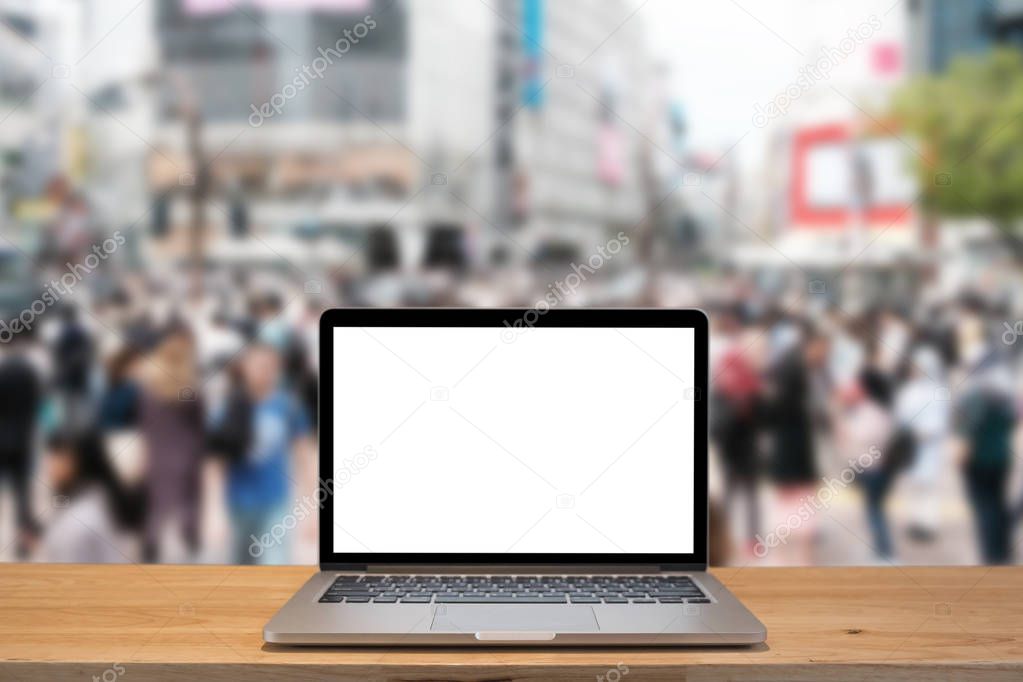 Laptop with blank screen on table with shibuya blurred backgroun