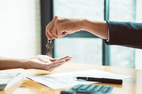 Agente de bienes raíces dando llaves de la casa al hombre y firmar un acuerdo en offi —  Fotos de Stock