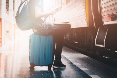 Backpacker smartphone bir gezgin ile tren istasyonunda üzerinden dinleme müzikler. Seyahat kavramı.