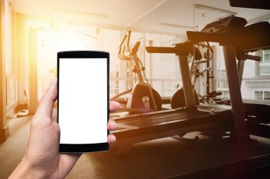 Akıllı telefon aygıtının boş ekran spor salonunda tutan bir adam el.